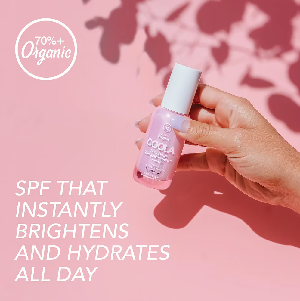 Hand holding a COOLA skincare product with text on a pink background
