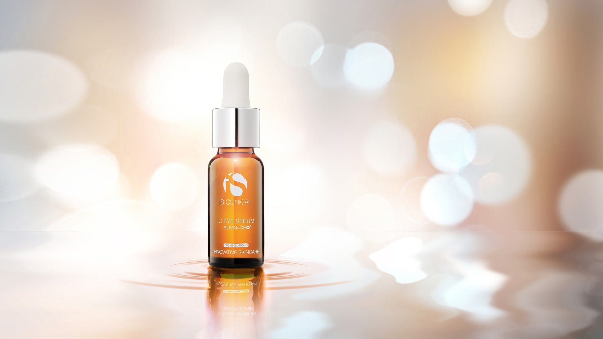 Orange serum bottle with dropper on a reflective surface with blurred lights in the background