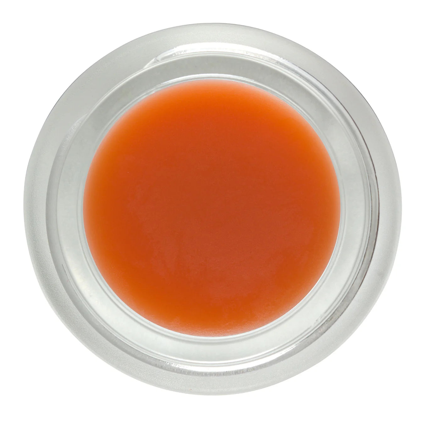 Small container of orange cream or paste on a white background