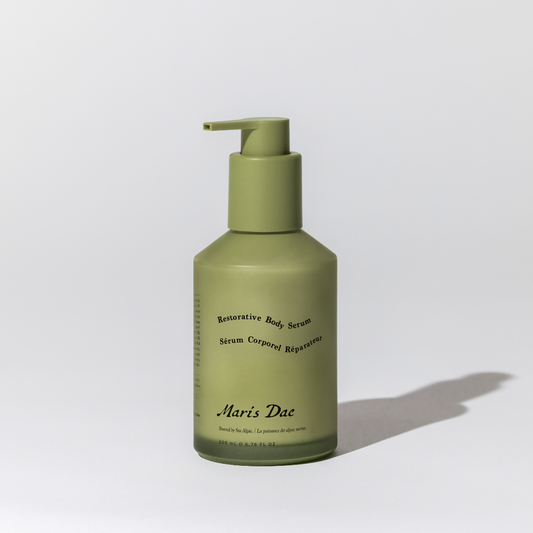 Green bottle with pump of 'Maris Dae' serum on a light gray background