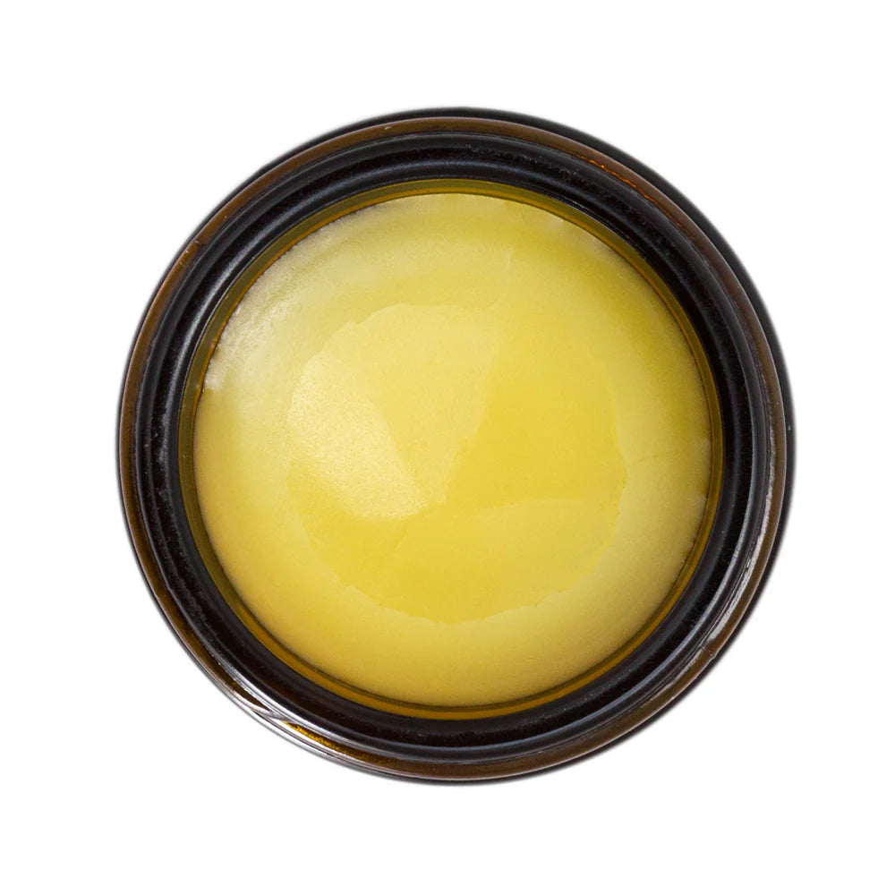 Jar of yellow cream on a white background