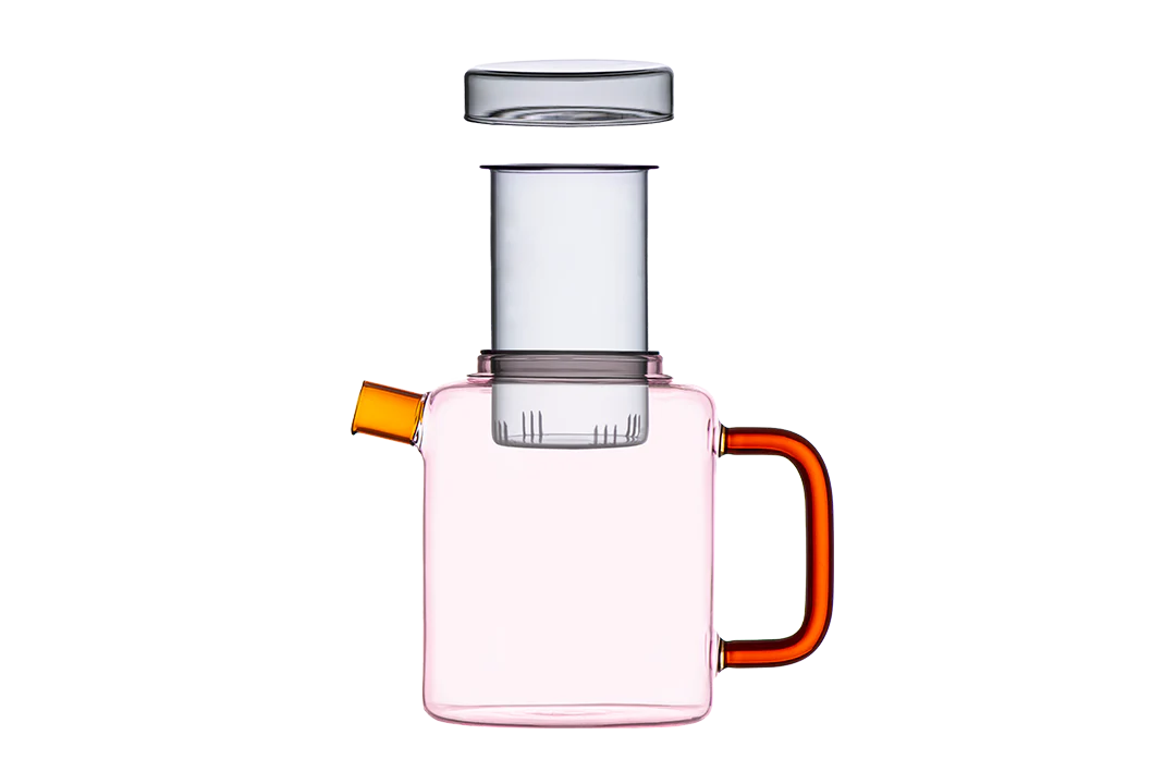 Pink glass carafe with orange handles on a white background