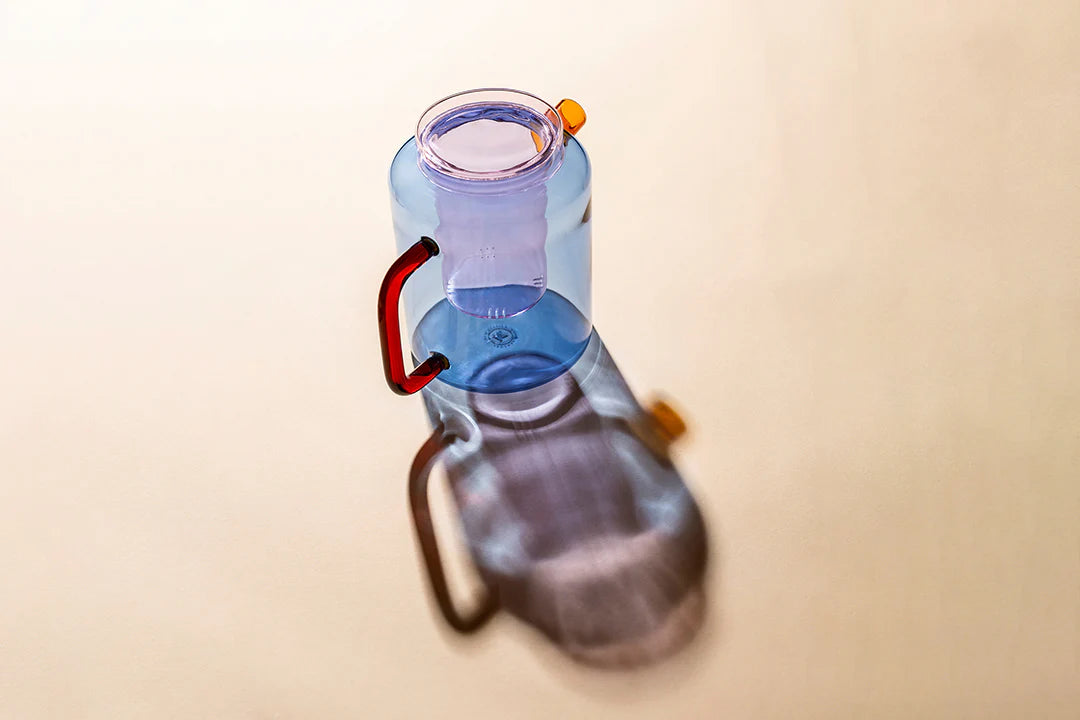 Close-up of a water bottle with a blue cap on a beige background
