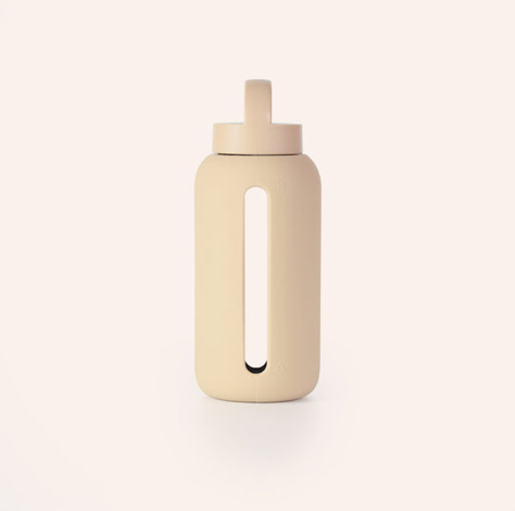 A cream coloured shell with glass insert water bottle with a silicone sleeve and a carrying cap.